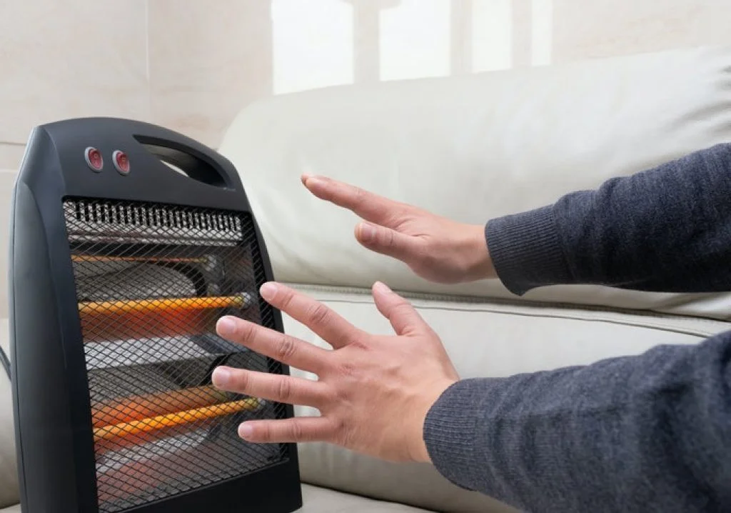 Mãos sendo aquecidas no melhor aquecedor elétrico 