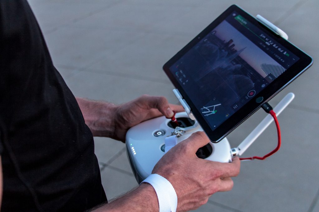 Mãos segurando o controle do melhor drone para filmagem