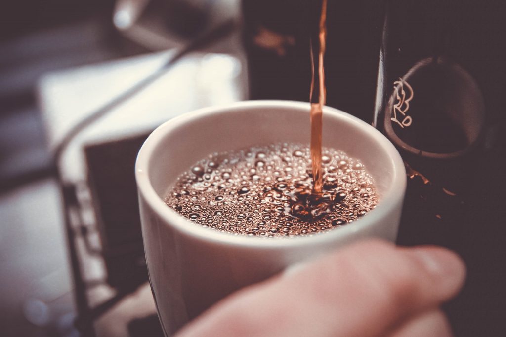Xícara de café recebendo a bebida da melhor cafeteira elétrica