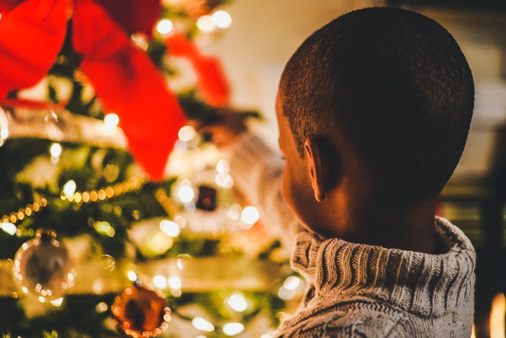 Menino em frente a uma árvore de Natal