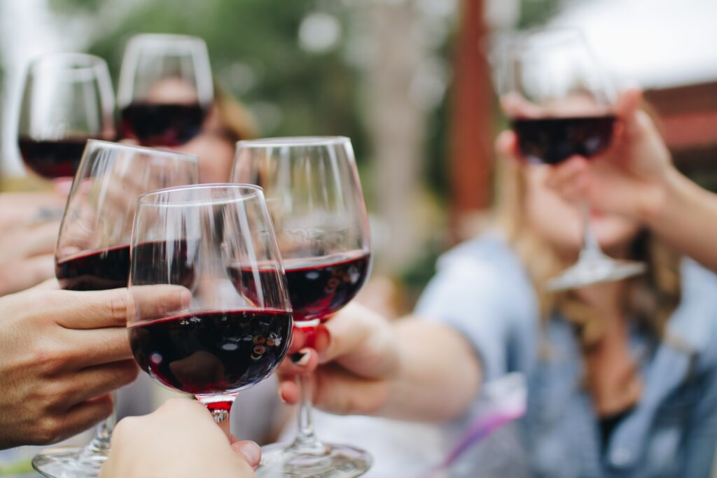 Pessoas brindando taças com os melhores vinhos brasileiros.